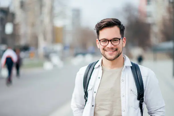 Photo of Portrait of a smiling student at the city street.