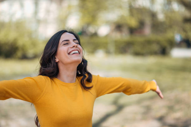 Positive young woman enjoying springtime in the park,portrait. Positive young woman enjoying springtime in the park,portrait. inhaling stock pictures, royalty-free photos & images