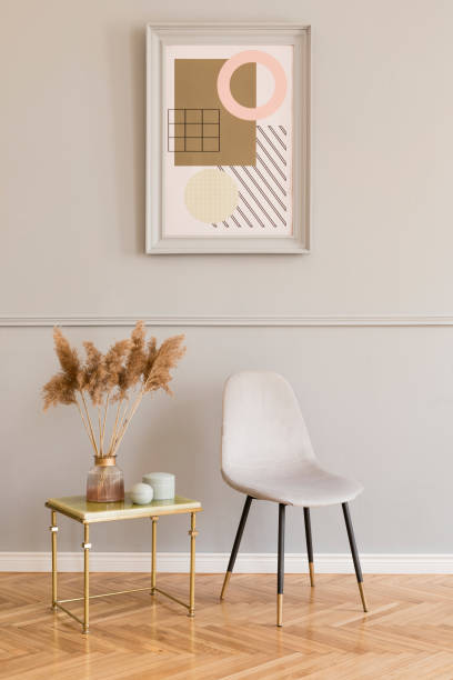 istock Minimalistic and luxury living room of apartment interior with elegant marble table, gray velvet chair and chic accessories. Mock up paintings frame on the molding gray wall. Stylish home decor. 1147290708