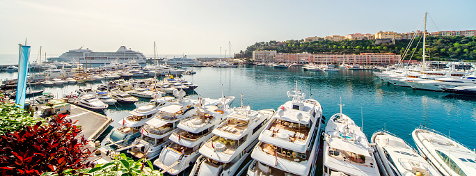 Panoramic view of port in Principality of Monaco, luxury yachts in a row picturesque landscape sunny day