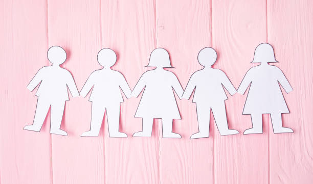 istock teamwork, paper people over pink background 1147292383