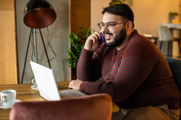 uomo d'affari in sovrappeso che fa una telefonata in mensa - heavy work foto e immagini stock