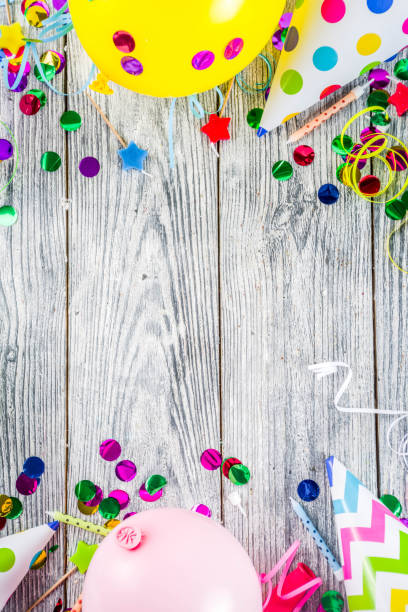 Birthday party decoration background with balloons, gift boxes, steamers and confetti, wooden white table copy space above