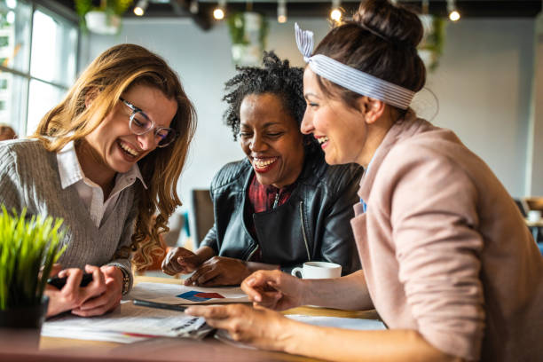 istock Female coworkers laughing in cafe 1147292726