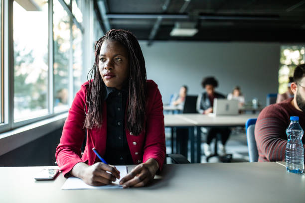 istock African woman looking through the window at work 1147294300