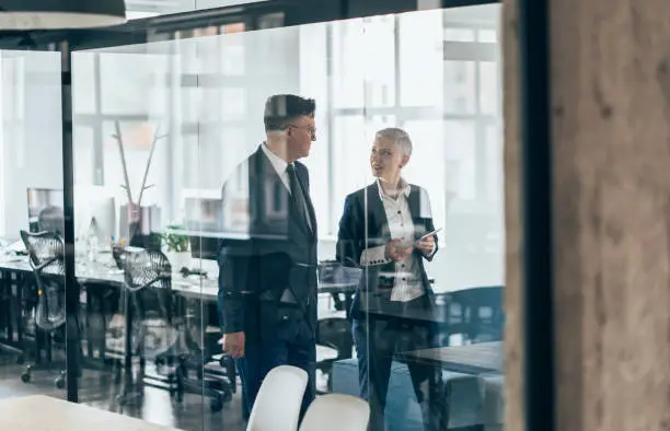 Business people walking and talking discussing ideas in the office