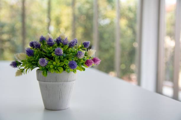 composition simple avec un bouquet de fleurs artificielles dans un pot de verre décoré. éléments de décor fait à la main rustique. style romantique. design vintage. violet, vert et rose colo - flower pot vase purple decor photos et images de collection