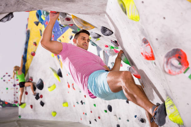 istock Male alpinist practicing indoor rock-climbing on artificial boulder without safety belts 1147295757