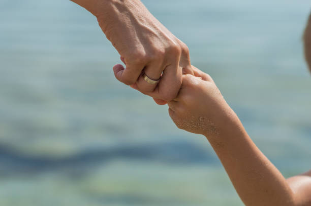 istock Mother holding hands of her daughter 1147295830