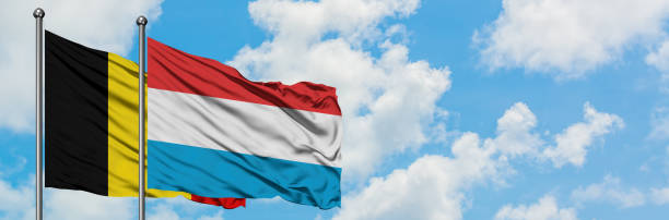 Belgium and Luxembourg flag waving in the wind against white cloudy blue sky together. Diplomacy concept, international relations. Belgium and Luxembourg flag waving in the wind against white cloudy blue sky together. Diplomacy concept, international relations. consul photos stock pictures, royalty-free photos & images