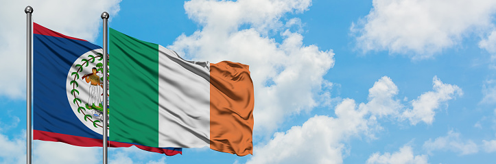 Belize and Ireland flag waving in the wind against white cloudy blue sky together. Diplomacy concept, international relations.