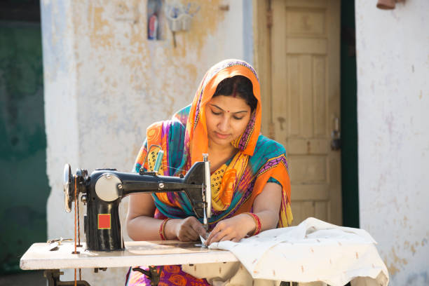 istock Indian women stitching cloths by machine at home - Stock image 1147299491