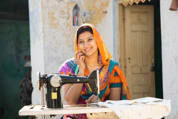 istock Indian women stitching cloths by machine at home - Stock image 1147299576