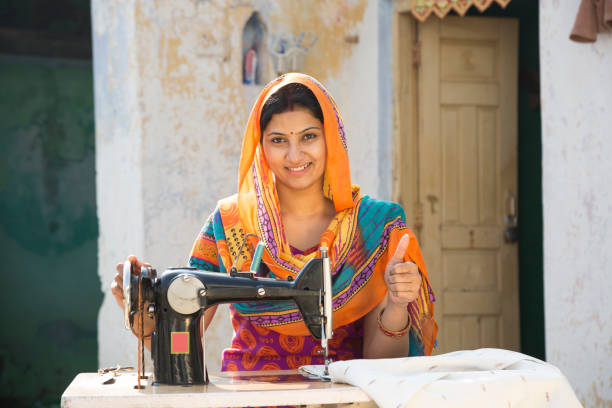 istock Indian women stitching cloths by machine at home - Stock image 1147299640