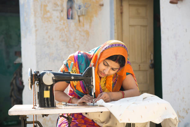 donne indiane che cucendo panni per macchina a casa - immagine di repertorio - sewing women tailor textile foto e immagini stock