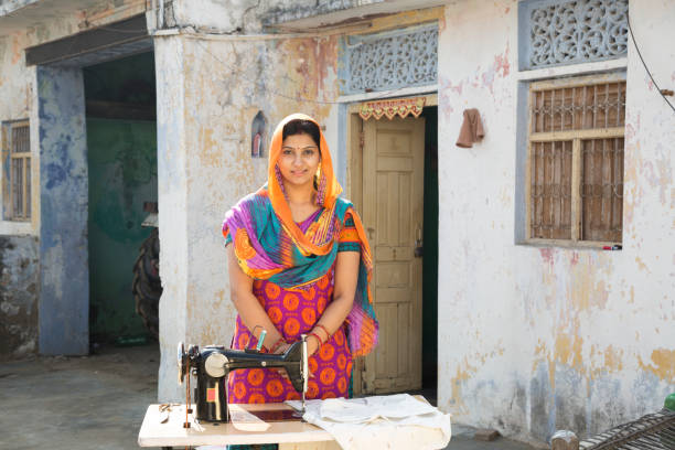 istock Indian women stitching cloths by machine at home - Stock image 1147299811