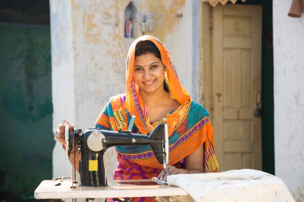 istock Indian women stitching cloths by machine at home - Stock image 1147299880
