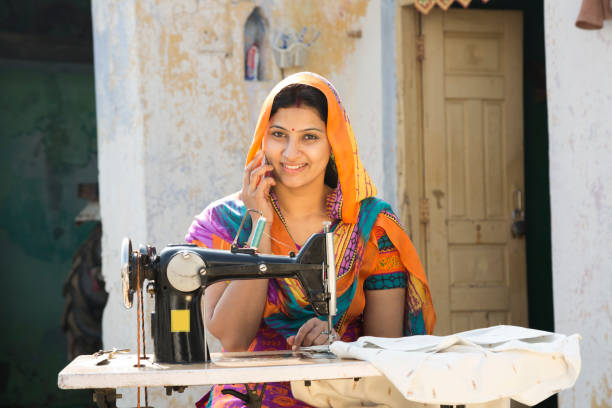 istock Indian women stitching cloths by machine at home - Stock image 1147299928
