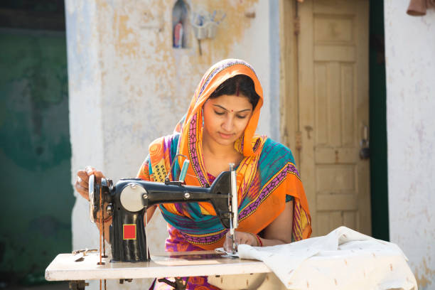 donne indiane che cucendo panni per macchina a casa - immagine di repertorio - sewing women tailor textile foto e immagini stock