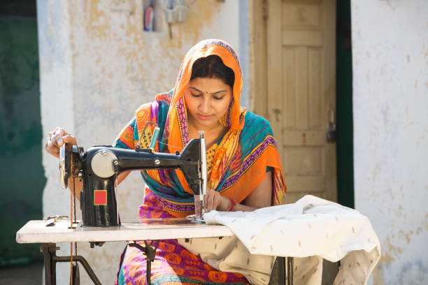 istock Indian women stitching cloths by machine at home - Stock image 1147300053