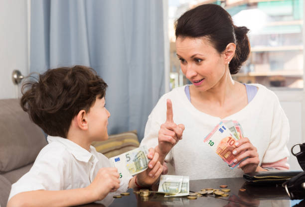 Woman giving money and admonishing boy Children and money concept. Woman admonishing teen boy while giving him money at home allowance stock pictures, royalty-free photos & images