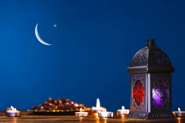 Moroccan, Arabic lantern and dates on on an old wooden table with the night sky and the Crescent moon and the star behind. Greeting card for Muslim community holy month Ramadan Kareem. Free space stock photo