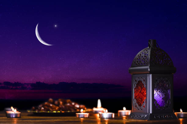 Ornamental dark Moroccan, Arabic lantern and dates on on an old wooden table with the night sky and the Crescent moon and the stars behind. Greeting card for Muslim community holy month Ramadan Kareem Ornamental dark Moroccan, Arabic lantern and dates on on an old wooden table with the night sky and the Crescent moon and the stars behind. Greeting card for Muslim community holy month Ramadan Kareem eid ul fitr photos stock pictures, royalty-free photos & images
