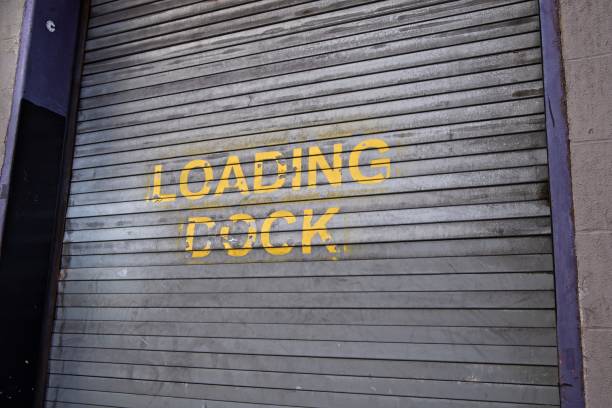 Loading dock door New York, NY, USA - May 6, 2019:A metallic door is used to seal a garage used for trucks unloading goods Garage Door Jerking stock pictures, royalty-free photos & images