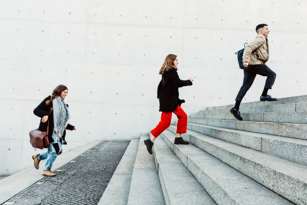 istock friends running up steps in urban setting 1147303320