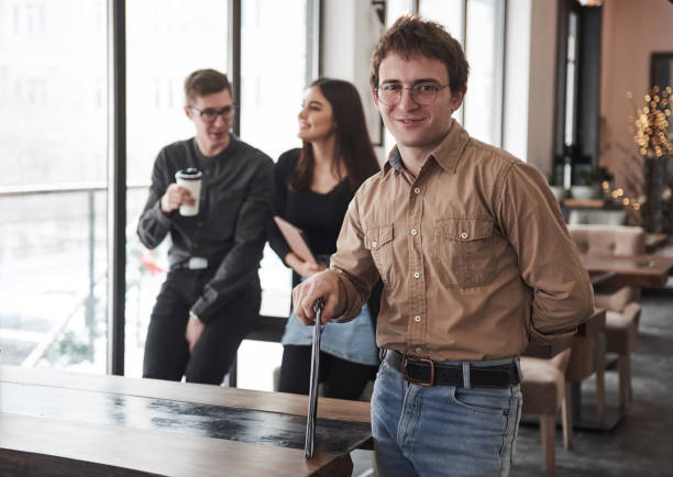 istock Cheerful mood. Group of students in eyewear standing in the learning room with documents 1147303335