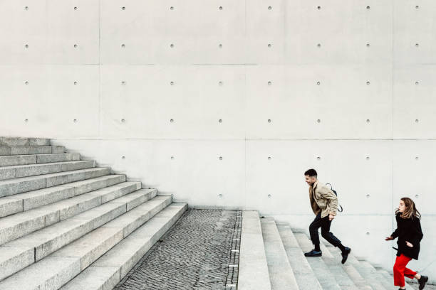 istock friends running up steps in urban setting 1147303463
