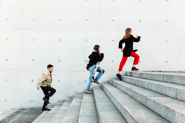 istock friends running up steps in urban setting 1147303518