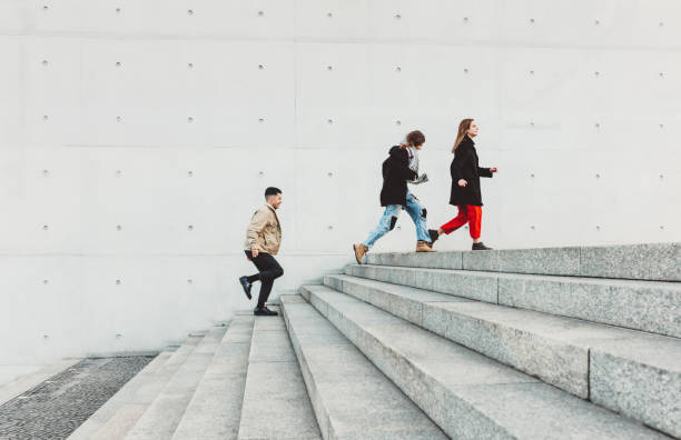 istock friends running up steps in urban setting 1147303608