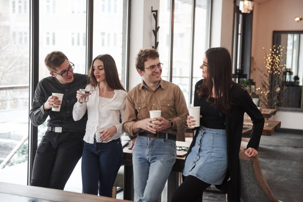 istock Drinking coffee and water. Group of students in eyewear standing in the learning room 1147303752