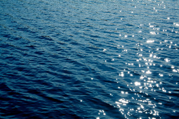 istock Beautiful deep blue lake water surface sun glare background texture 1147303762