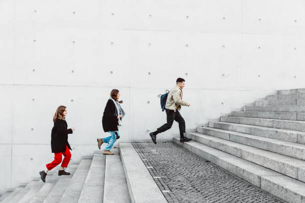 istock friends running up steps in urban setting 1147303795