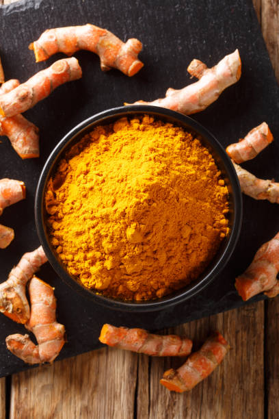 istock Fresh turmeric spice in a bowl and root close-up. Vertical top view 1147307011