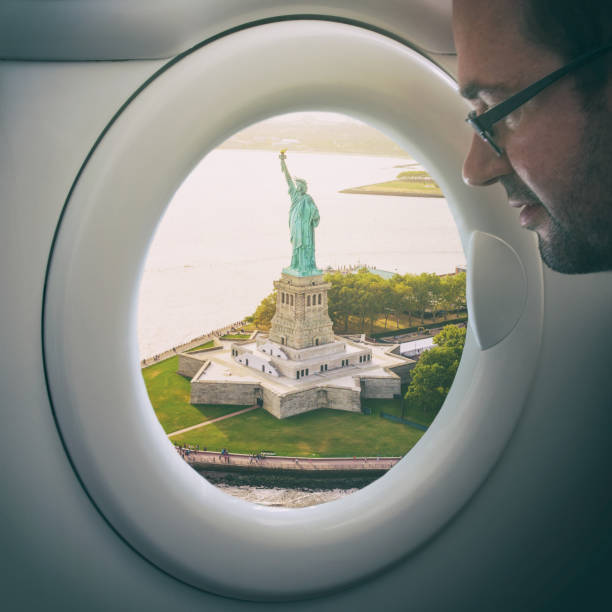 istock man looking statue of liberty from a fake window plane 1147308701