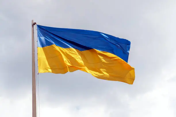 Photo of flag of Urkaine on the gray sky background
