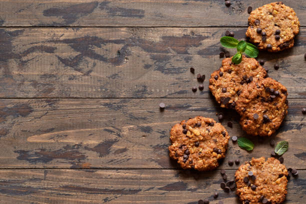 bolinhos de oatmeal com gotas do chocolate em um fundo de madeira. vista de cima. - oat oatmeal isolated stack - fotografias e filmes do acervo