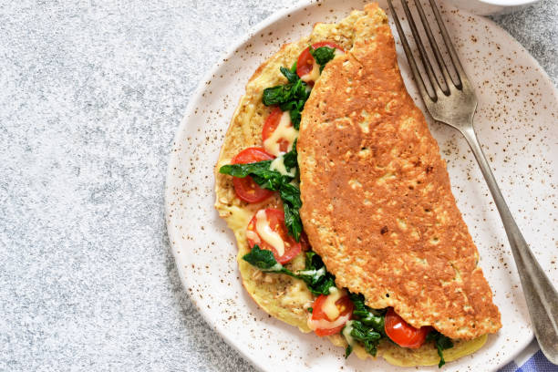 istock Omelet with tomatoes, cheese and basil in a plate on the kitchen table. View from above. 1147309712