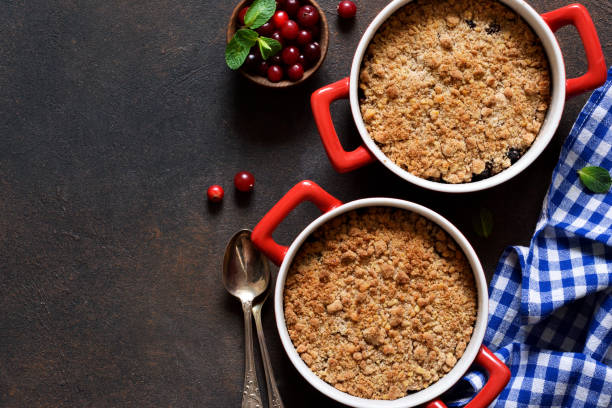 crumble con arándanos y otras bayas, nueces en la mesa de la cocina. vista desde arriba. - apple portion red freshness fotografías e imágenes de stock