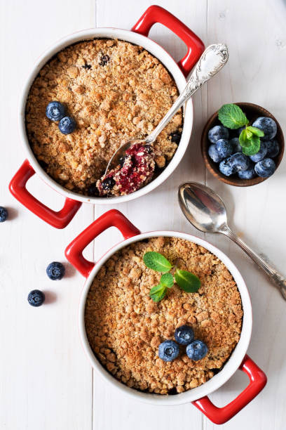 crumble con arándanos en una mesa de cocina blanca. vista desde arriba. - apple portion red freshness fotografías e imágenes de stock