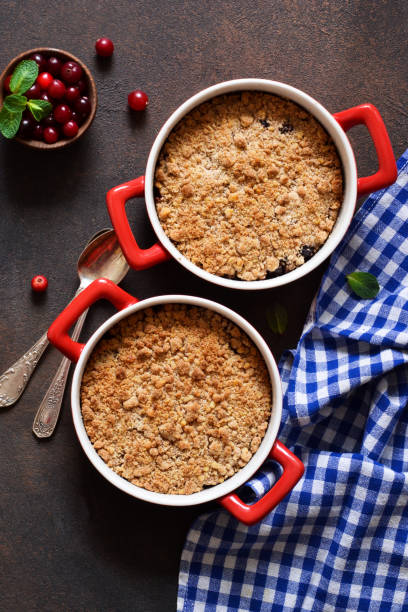 sbriciolare con mirtilli rossi e altre bacche, noci sul tavolo della cucina. vista dall'alto. - apple and currant bread foto e immagini stock