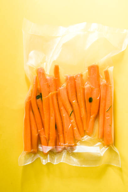 istock Vacuum sealed vegetables , carrots, on a yellow background top view, ready o be cooked with sous vide rooner 1147310195