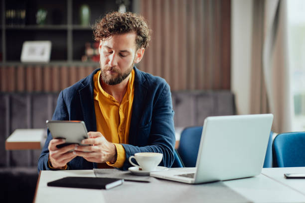 Businessman sitting in cafe and using tablet.