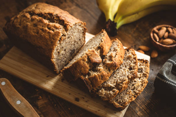 Banana Bread Loaf On Wooden Table Banana Bread Loaf Sliced On Wooden Table. Wholegrain Banana Cake With Nuts vegan food photos stock pictures, royalty-free photos & images
