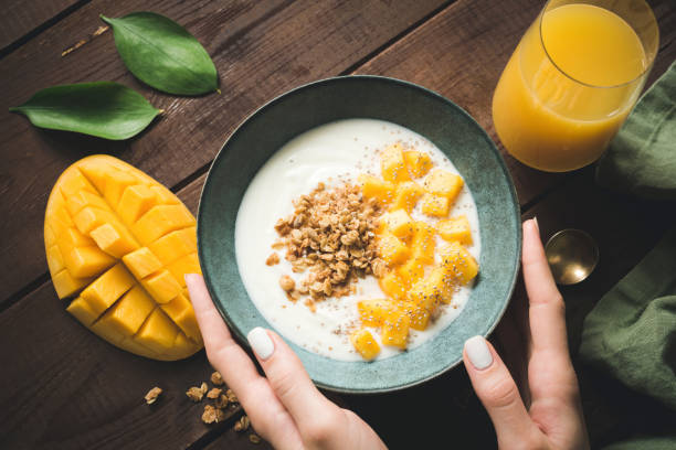 Bowl of yogurt with mango and granola for breakfast Bowl of yogurt with mango, chia seeds and granola. Healthy breakfast, healthy lifestyle concept. Top view eating chia seeds stock pictures, royalty-free photos & images
