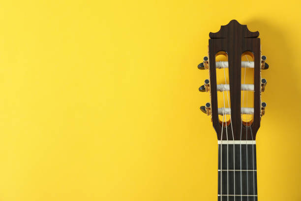 istock Guitar neck on yellow background, space for text 1147314786