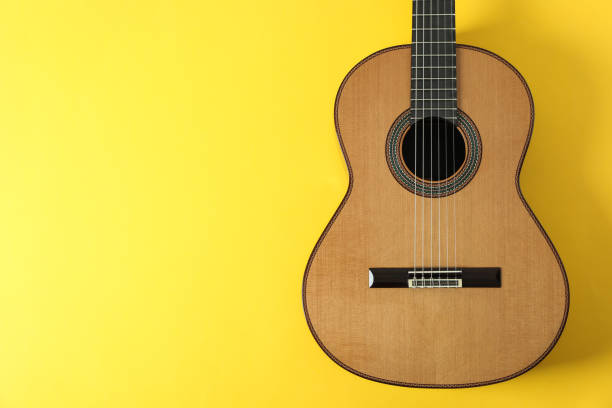 istock Beautiful classic guitar on yellow background, space for text 1147314849
